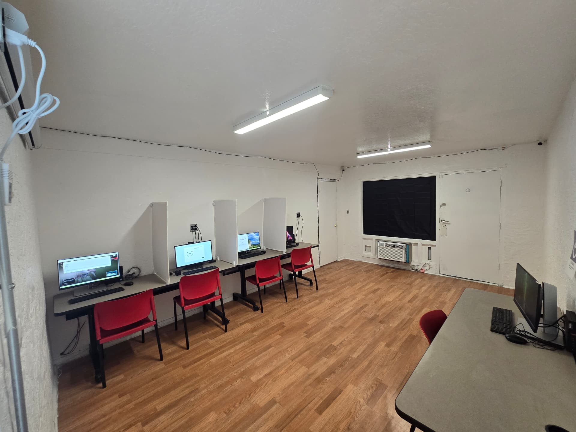 Proctored testing room with privacy dividers and HD monitors